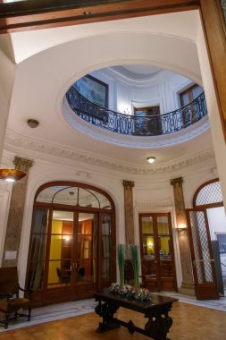 Kemerli kapı aralıkları ve balkon tavanı olan zarif bir giriş salonu.