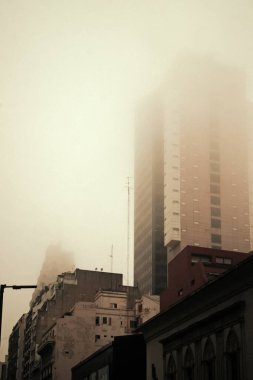 Uzun şehir binaları yoğun siste kayboluyor.