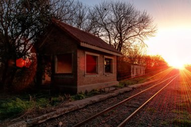 Gün batımında terk edilmiş tren istasyonu binası
