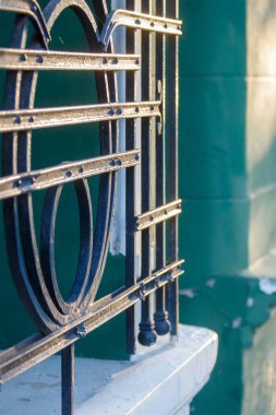 Güneş ışığı dekoratif metal pencere ızgarasına vuruyor