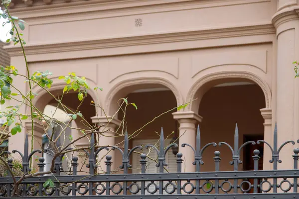 Kemerli pencerelerin, demir çitlerin olduğu tarihi bina cephesi