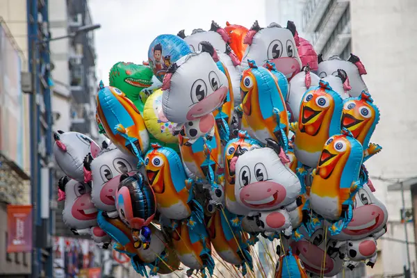 Şehir caddesinde yüzen renkli hayvan balonları