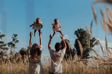 Bir aile doğanın ortasında iki çocuk, ikiz kız kardeş ile yürür; ebeveynler doğanın ortasına ikiz kız kardeşler bırakır; çocuklar gökyüzünün arka planında