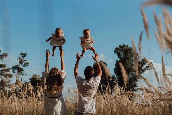 stock image a family walks in the middle of nature with two children, twin sisters; parents drop twin sisters in the middle of nature;  children on the background of the sky