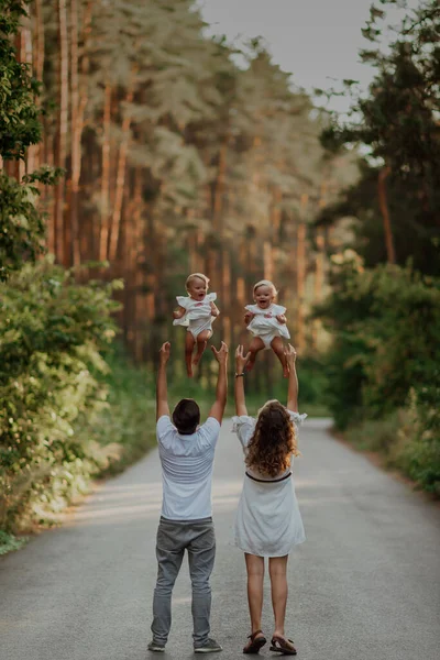Bir Aile Doğanın Ortasında Iki Çocukla Yürür Ikiz Kız Kardeşler — Stok fotoğraf