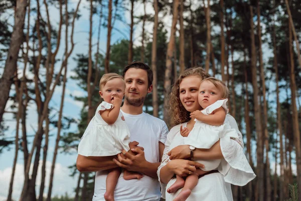 Bir Aile Doğanın Ortasında Iki Çocuk Ikiz Kız Kardeşle Yürür — Stok fotoğraf