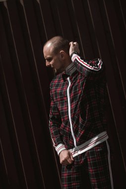 Erkek portresi sokakta gün ışığında, kırmızı ve siyah bir takım elbise giymişti.