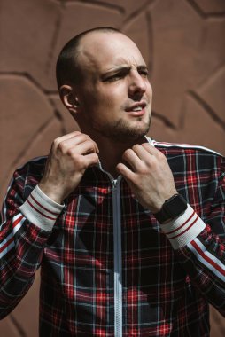 Erkek portresi sokakta gün ışığında, kırmızı ve siyah bir takım elbise giymişti.