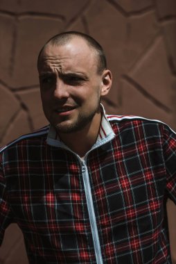 Erkek portresi sokakta gün ışığında, kırmızı ve siyah bir takım elbise giymişti.