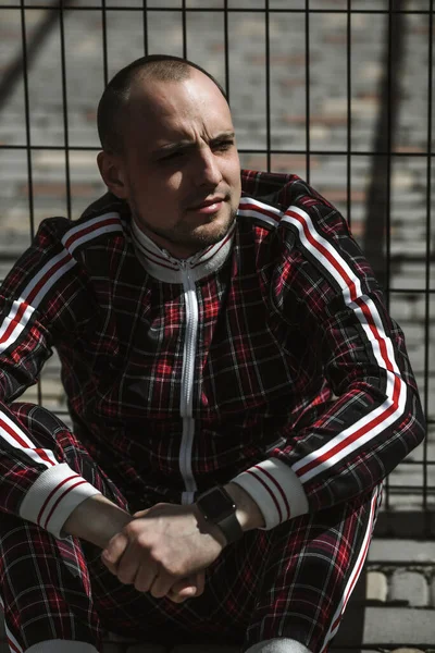 stock image male portrait on the street in sunlight; dressed in a red and black suit