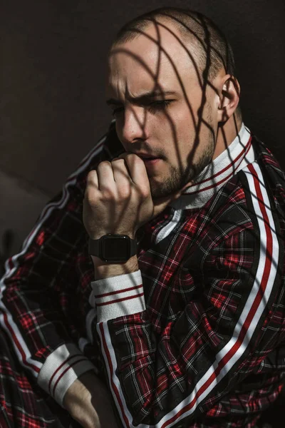 stock image male portrait on the street in sunlight; dressed in a red and black suit