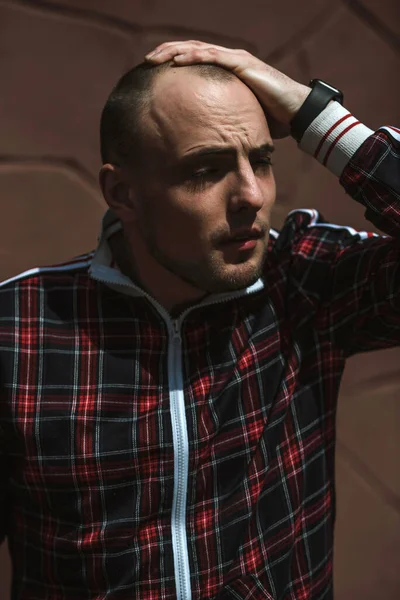 Erkek portresi sokakta gün ışığında, kırmızı ve siyah bir takım elbise giymişti.