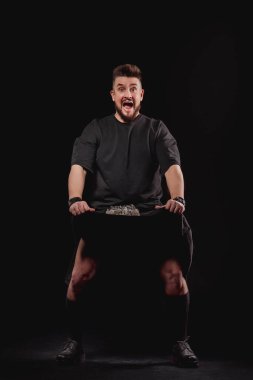 Stüdyoda siyah bir arkaplanda İskoç omurgası takan erkek portresi. Kameraya bakın.