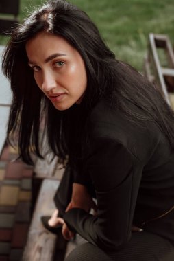 Siyah saçlı, sokakta siyah takım elbiseli güzel bir kız.