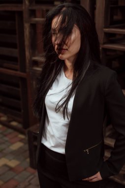 Siyah saçlı, sokakta siyah takım elbiseli güzel bir kız.