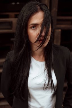 Siyah saçlı, sokakta siyah takım elbiseli güzel bir kız.