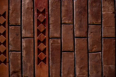 Dekorun bir parçası ve yapıldığı malzeme; dekoratif eklentileri olan eski kırmızı tuğla duvar