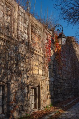 Binanın ön cephesinin bir parçası ve inşa edildiği malzeme; mavi gökyüzü arka planında antika fenerli eski duvar