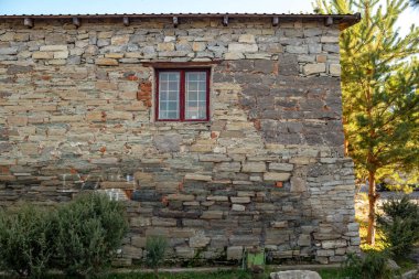 Binanın ön cephesinin bir parçası ve inşa edildiği malzeme; eski taş ev ve pencere