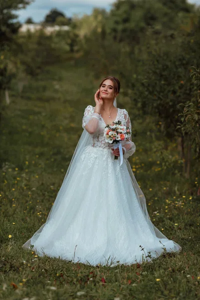 Μια Νεαρή Όμορφη Νύφη Ποζάρει Ένα Γαμήλιο Μπουκέτο Στο Φόντο Royalty Free Φωτογραφίες Αρχείου