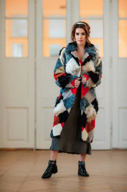 Kürk manto giymiş seksi bir kız ve kapının arkasında poz veriyor; sıcak, uzun kürk manto.