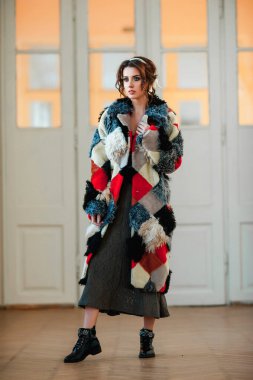 Kürk manto giymiş seksi bir kız ve kapının arkasında poz veriyor; sıcak, uzun kürk manto.