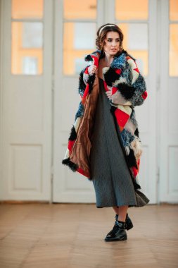 Kürk manto giymiş seksi bir kız ve kapının arkasında poz veriyor; sıcak, uzun kürk manto.