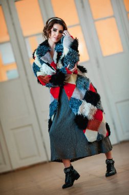 Kürk manto giymiş seksi bir kız ve kapının arkasında poz veriyor; sıcak, uzun kürk manto.