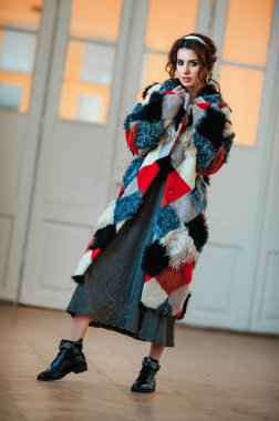 Kürk manto giymiş seksi bir kız ve kapının arkasında poz veriyor; sıcak, uzun kürk manto.