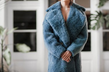 Kürk manto giymiş seksi bir kız ve kapının arkasında poz veriyor; sıcak, uzun kürk manto.