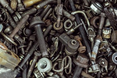 çok sayıda eski paslı ve yağ lekeli araba parçaları.