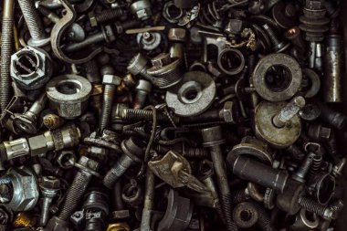çok sayıda eski paslı ve yağ lekeli araba parçaları.