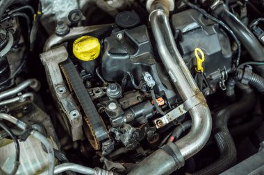 Kaputun altında parçalanmış kirli bir araba motoru var.