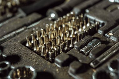 araba tamiri için birçok araç; kirli yağlı araçlar; krom yüzeyli tamir kitleri; anahtarlar, nozüller, pense, tornavida, somunlar, cıvatalar,