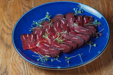 Dishes from the chef of the restaurant. A dish on a table in a cafe. Appetizing food from the restaurant menu. Fresh and tasty food. ready meals in the cafe. sliced meat in a blue plate