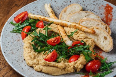 Dishes from the chef of the restaurant. A dish on a table in a cafe. Appetizing food from the restaurant menu. Fresh and tasty food. tomato and green salad with porridge and bread