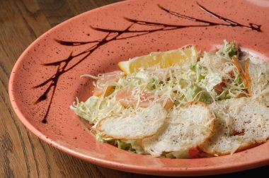 Dishes from the chef of the restaurant. A dish on a table in a cafe. Appetizing food from the restaurant menu. Fresh and tasty food. vegetable salad with bread and pieces of salmon sprinkled with cheese