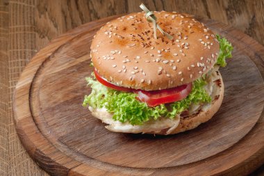 hamburger with a latch on a wooden board on the table. Delicious fast food. A product made by a chef in a cafe