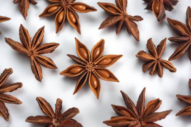 Fragrant spices for preparing drinks and desserts. Food additive in dishes. Brown spices. Spices for making mulled wine. A lot of star anise on a white background close-up