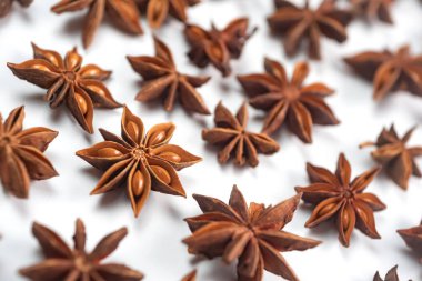 Fragrant spices for preparing drinks and desserts. Food additive in dishes. Brown spices. Spices for making mulled wine. A lot of star anise on a white background close-up