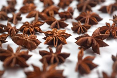 Fragrant spices for preparing drinks and desserts. Food additive in dishes. Brown spices. Spices for making mulled wine. A lot of star anise on a white background close-up
