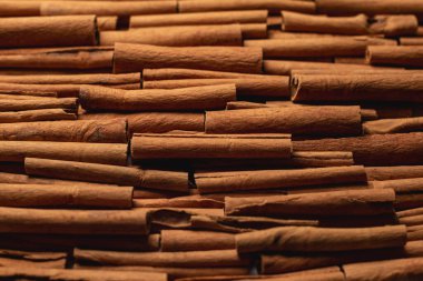 Fragrant spices for preparing drinks and desserts. Food additive in dishes. Brown spices. Spices for making mulled wine. Many cinnamon rolls stacked in an even order, top view