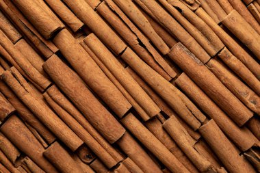 Fragrant spices for preparing drinks and desserts. Food additive in dishes. Brown spices. Spices for making mulled wine. Many cinnamon rolls stacked in an even order, top view