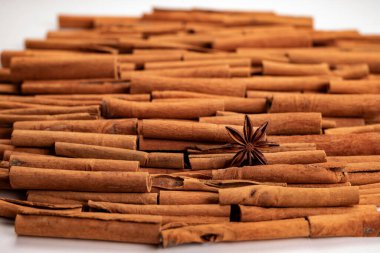 Fragrant spices for preparing drinks and desserts. Food additive in dishes. Brown spices. Spices for making mulled wine. Star anise lies on a large number of cinnamon rolls