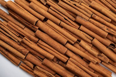 Fragrant spices for preparing drinks and desserts. Food additive in dishes. Brown spices. Spices for making mulled wine. Many cinnamon rolls stacked in an even order, top view