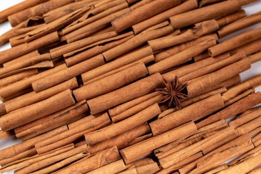 Fragrant spices for preparing drinks and desserts. Food additive in dishes. Brown spices. Spices for making mulled wine. Star anise lies on a large number of cinnamon rolls