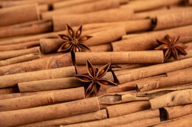 Fragrant spices for preparing drinks and desserts. Food additive in dishes. Brown spices. Spices for making mulled wine. Star anise lies on a large number of cinnamon rolls