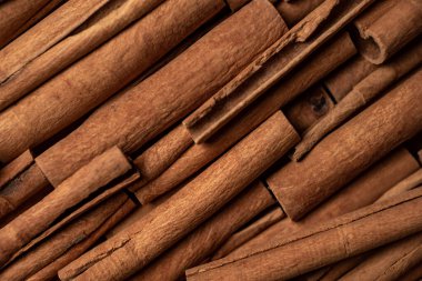 Fragrant spices for preparing drinks and desserts. Food additive in dishes. Brown spices. Spices for making mulled wine. Many cinnamon rolls stacked in an even order, top view