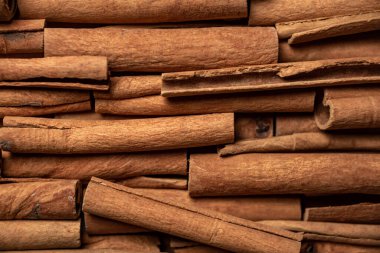 Fragrant spices for preparing drinks and desserts. Food additive in dishes. Brown spices. Spices for making mulled wine. Many cinnamon rolls stacked in an even order, top view