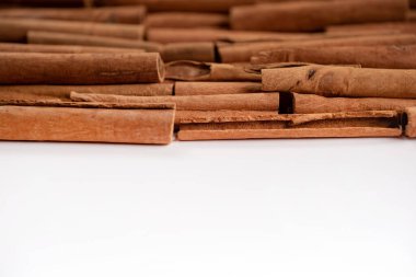 Fragrant spices for preparing drinks and desserts. Food additive in dishes. Brown spices. Spices for making mulled wine. Cinnamon rolls lie on a white background, top view